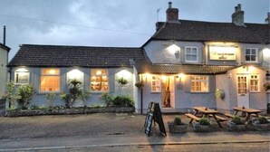 A pub with outdoor seating, a signboard, and a car park sign. - Woodman Inn (Bedale)