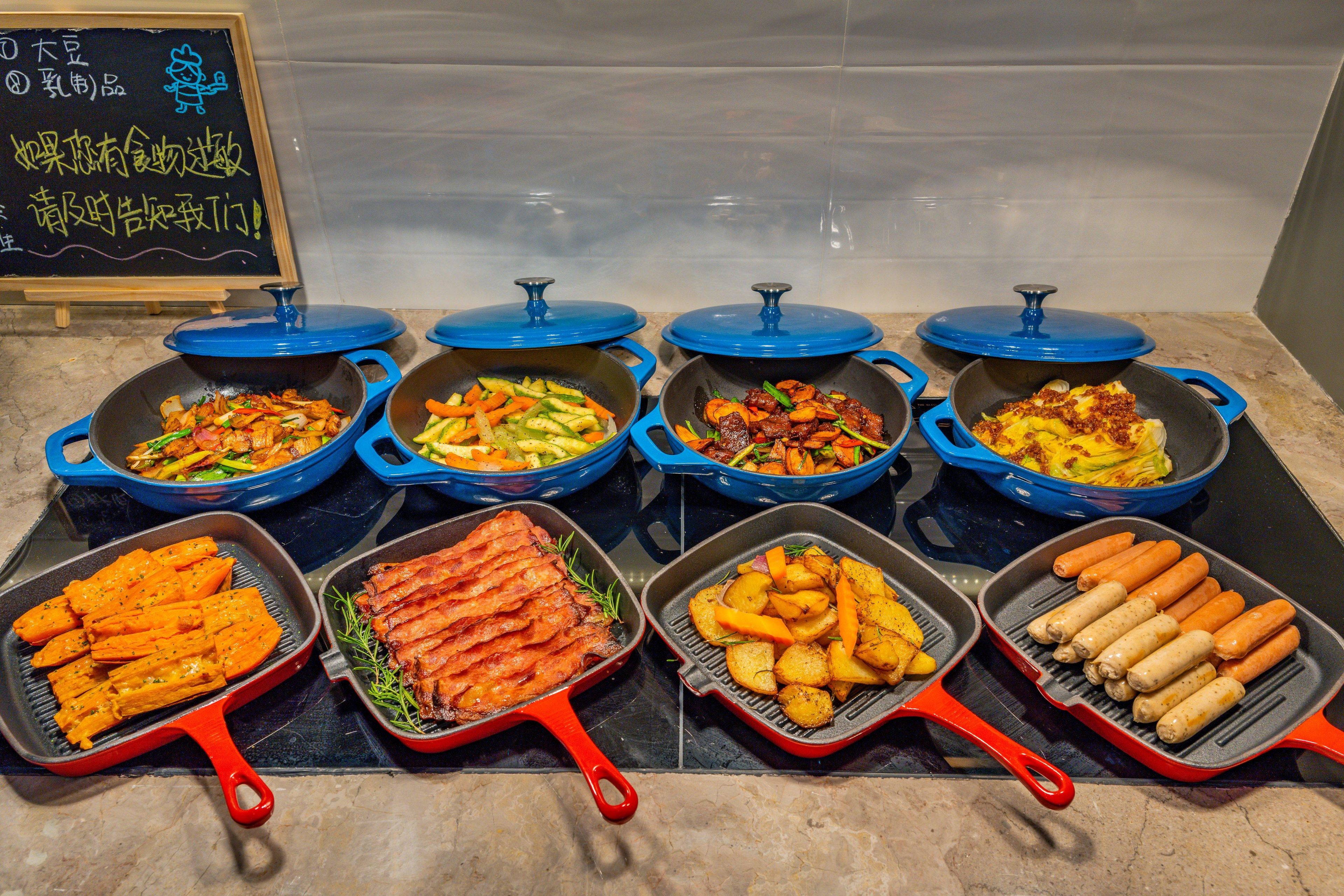 A variety of food items in different cooking pans on a kitchen counter.