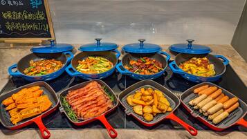 A variety of food items in different cooking pans on a kitchen counter.