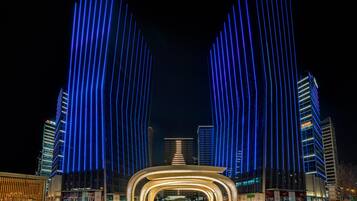 Un edificio moderno con una entrada curva y franjas verticales de luz.
