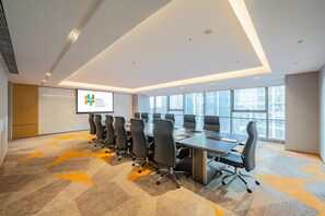 A conference room with a long table, multiple chairs, a projector screen, and large windows. - Even Suzhou Grand Canal (Suzhou)