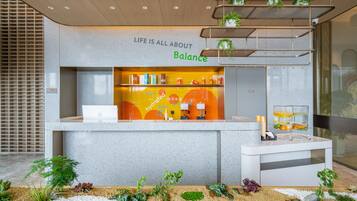 Un mostrador de recepción con un cartel que dice 'Life is all about Balance', una computadora portátil y una estación de agua.