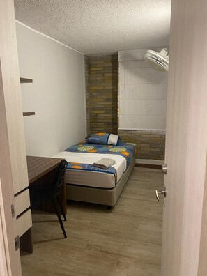 A bedroom with a bed, a desk, and a chair. - Apartahotel Livinnx Barranquilla (Puerto Colombia)