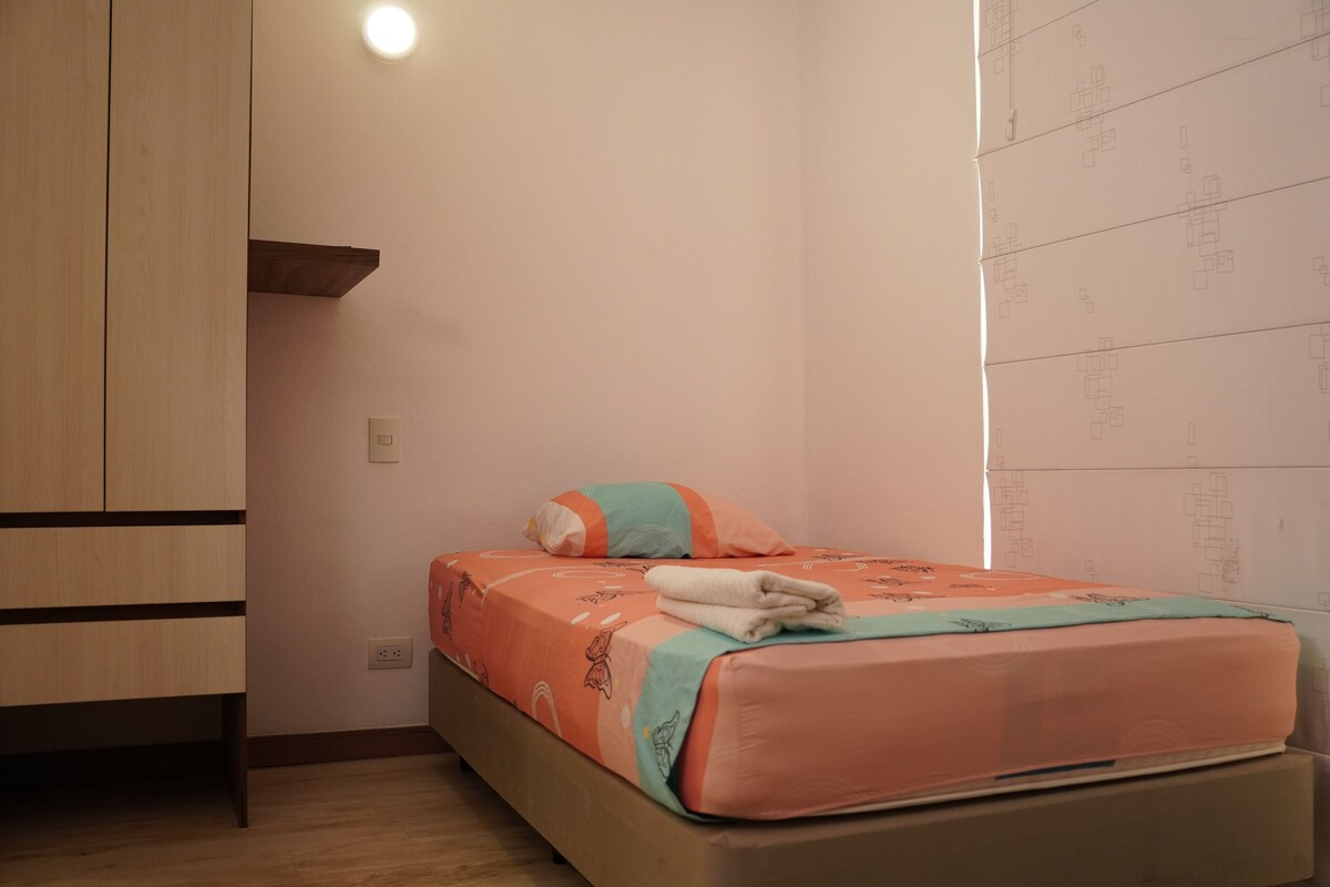 Un dormitorio con una cama, un armario y una pared con diseño.