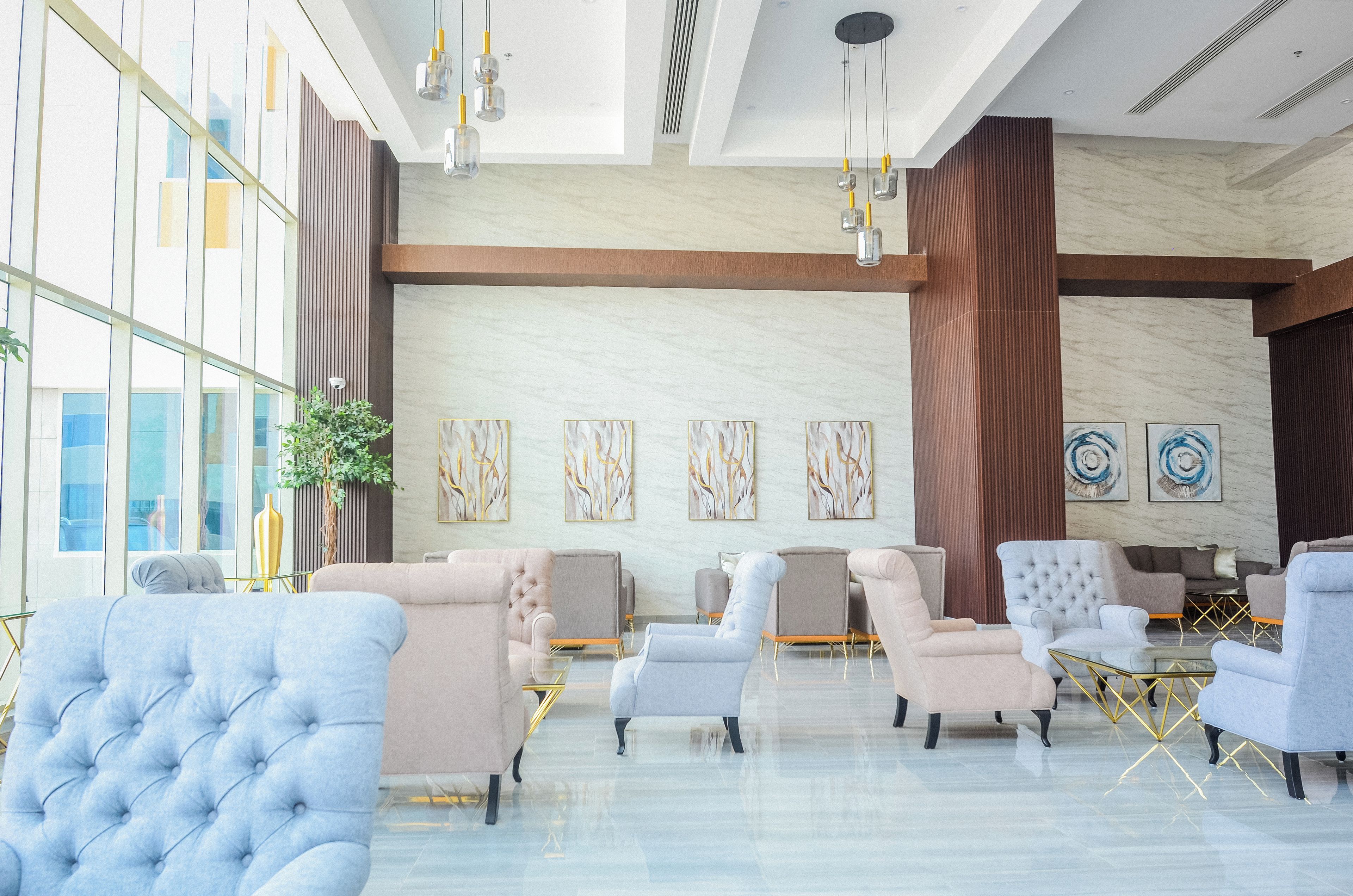 A modern lobby with a marble floor, multiple seating areas, and artwork on the walls.
