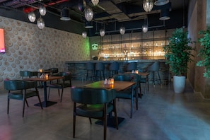 Un espace bar avec un mur décoré de motifs, un comptoir et des sièges.