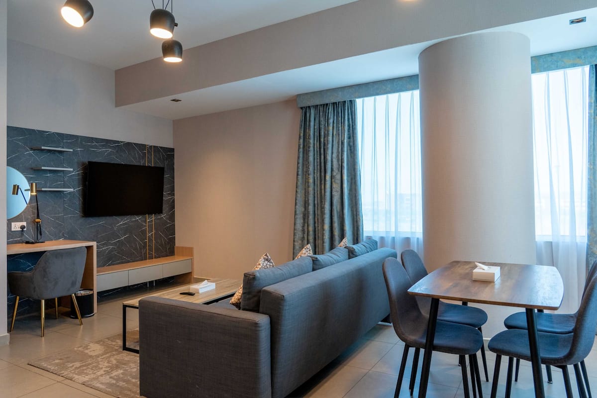 Una sala de estar moderna con sofá, mesa de comedor y televisor.