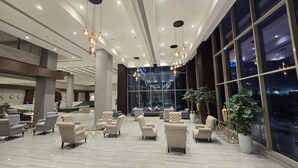 A spacious lobby with modern furniture, large windows, and hanging pendant lights. - Vogo Grand Hotel (Dubai)
