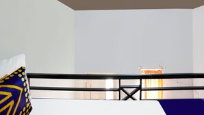 Una habitación con cama, ventana con cortinas y baranda de metal.
