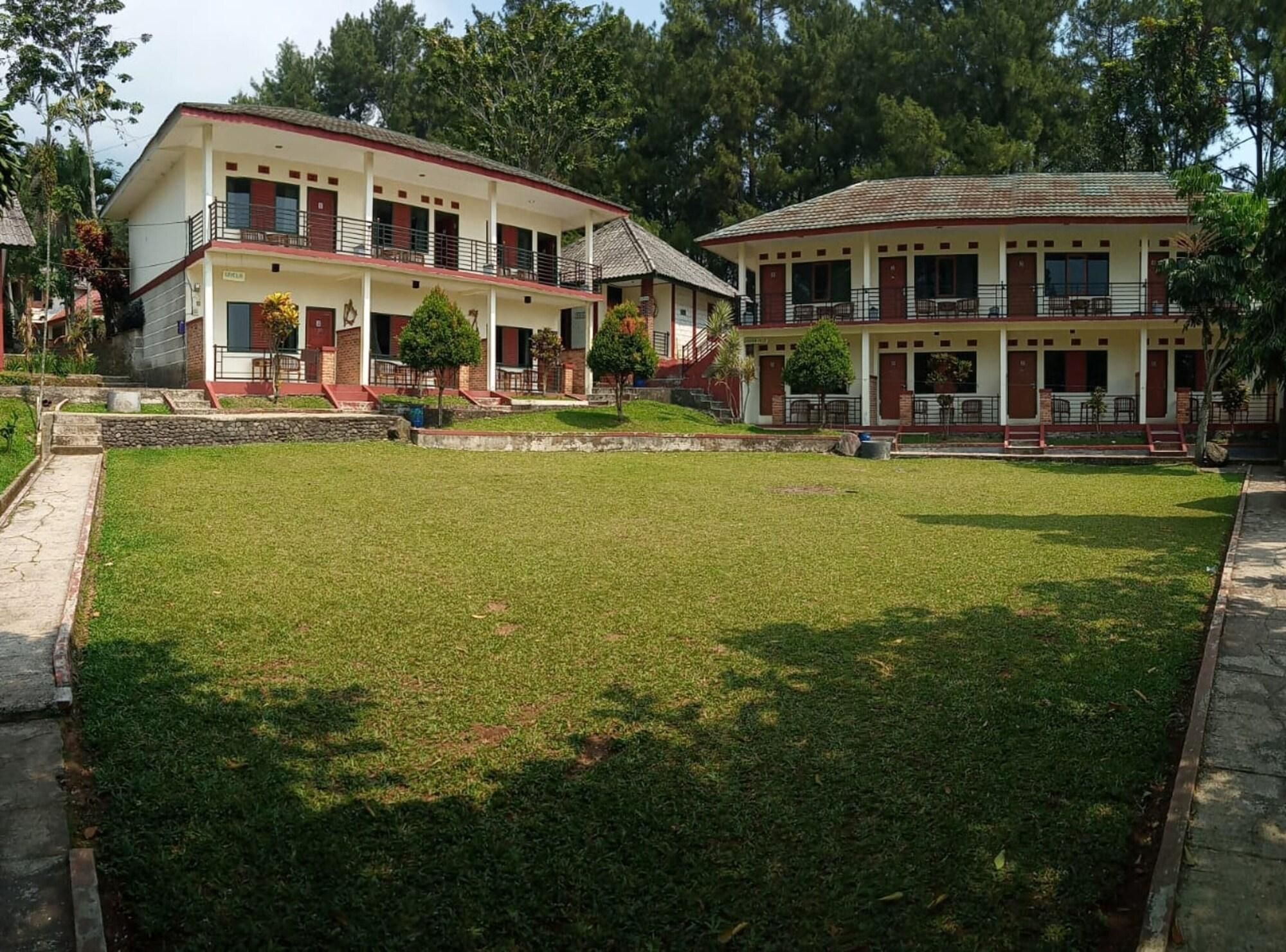 A two-story building with a flat roof, a central entrance, and a small front garden.