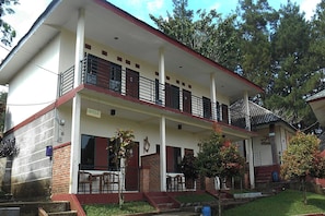 A two-story building with a balcony, a covered porch, and a brick lower level. - Cunang Hill Hotel & Resort by Zuzu (Cilobak)