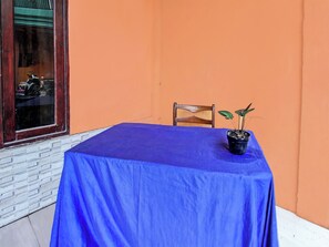 Une pièce avec une table bleue, une chaise et une plante en pot.