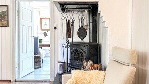 A cozy living room with a fireplace, a sofa, and a door leading to another room. - Beautiful home in Bagn with WiFi (Bagn)
