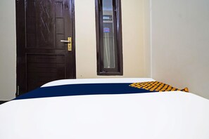 Una stanza con un letto, una porta e una finestra.