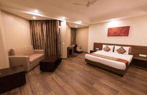 A hotel room with a bed, a sofa, a desk, and a chair. - Le Roi Digha@ Digha Railway Station (Kanthi)