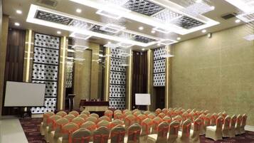A conference room with rows of chairs, a podium, and a projection screen.