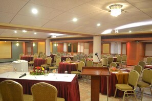 A conference room with round tables, chairs, and a podium. - Regenta Place The Emerald (Mumbai)