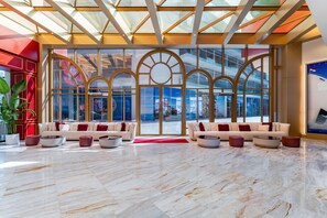 Un vestíbulo amplio con techo alto, ventanas grandes y una decoración de estilo moderno.