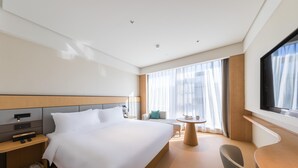 A hotel room with a large bed, bedside tables, a desk, a chair, a TV, and a window with curtains. - Ji Hotel Beijing Beiqing Road Zhongguancun Environ (Beijing)