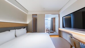A hotel room with a large bed, a desk with a chair, a television, and a view of the outside. - Ji Hotel Beijing Beiqing Road Zhongguancun Environ (Beijing)