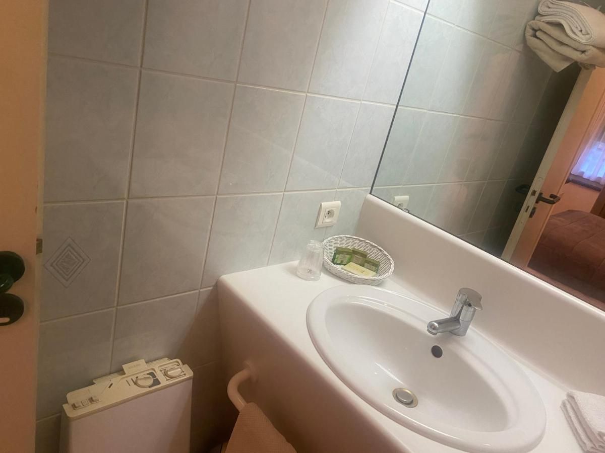 Une salle de bain avec un lavabo blanc, un miroir et un porte-serviettes.