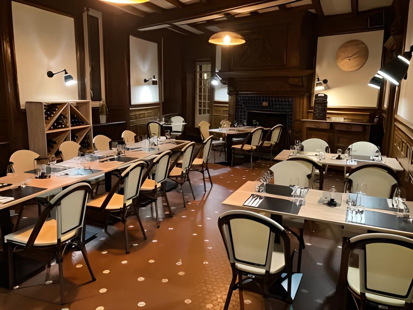 Une salle de conférence dotée de plusieurs tables et chaises, d’une cheminée et d’un éclairage suspendu.