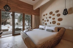 Um quarto espaçoso com uma cama grande, teto de madeira e vista para um pátio.