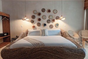 Un dormitorio moderno con una cama grande, un muro de espejos circulares y dos lámparas colgantes.