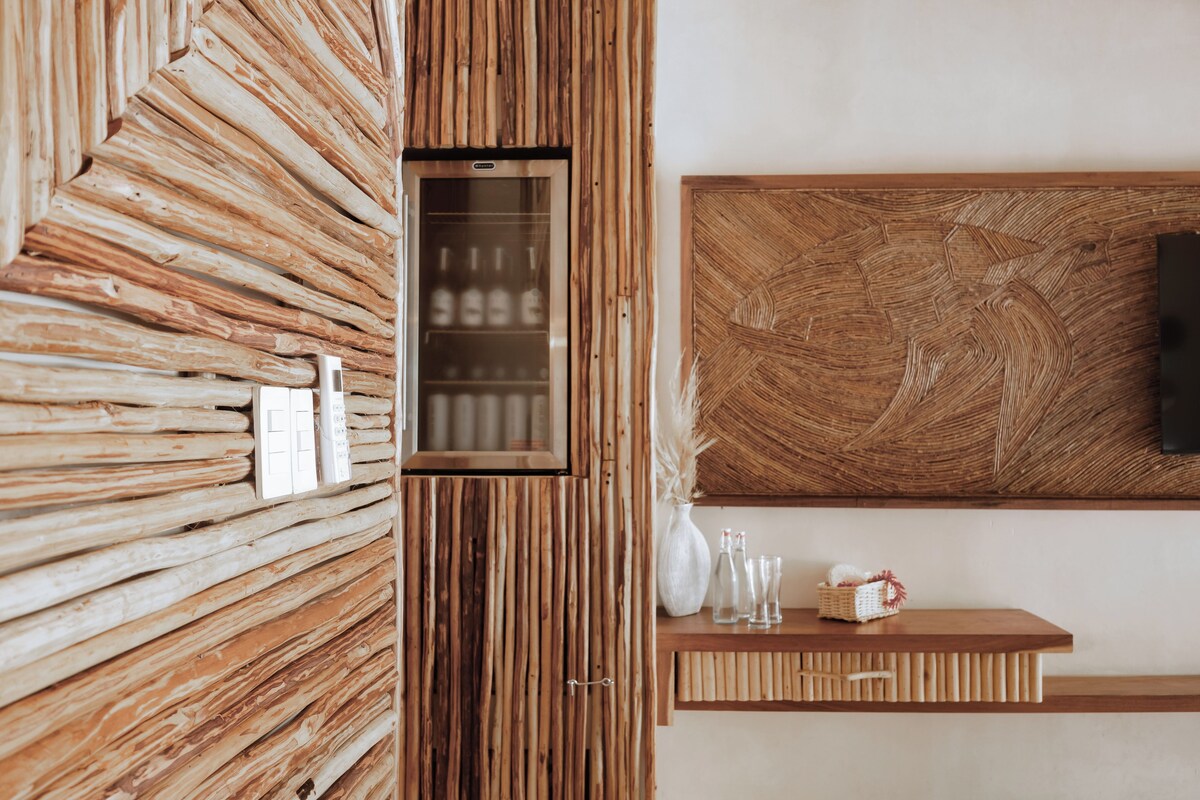 Un interior moderno con un panel de madera, un enfriador de vino empotrado y un televisor montado.