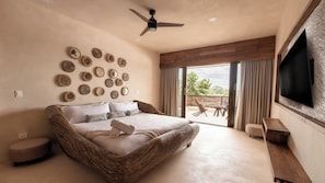 A spacious bedroom with a large bed, a ceiling fan, and a view of the outdoors through a sliding glass door. - Cervecería Tulum Boutique Hotel & Beer Spa (Tulum)