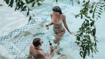 Dos personas en una piscina con un diseño geométrico en el suelo.