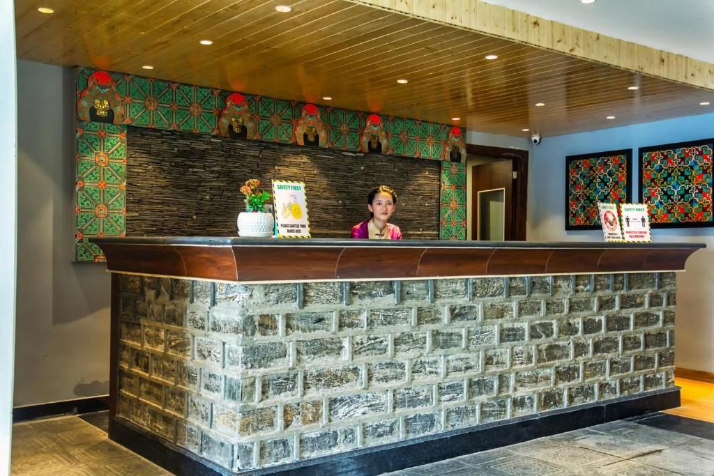 Un mostrador de recepción con fachada de piedra, techo de madera y diseños decorativos en las paredes.