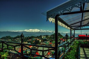 A scenic overlook with a metal railing, a view of a town below, and snow-capped mountains in the distance. - Sumitel Vista 800m From Mall Road (Darjeeling)