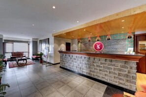 A reception area with a stone wall, wooden ceiling, and a reception desk. - Sumitel Vista 800m From Mall Road (Darjeeling)