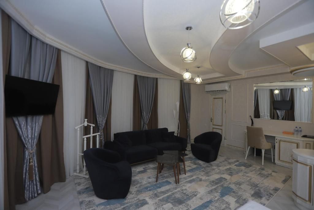 A modern living room with a sectional sofa, a flat-screen TV, a desk with a chair, and a large mirror.