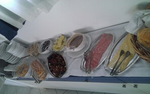 A buffet table with various food items and utensils.