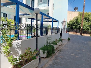 A building with a pool, a blue and white color scheme, and a gated entrance.