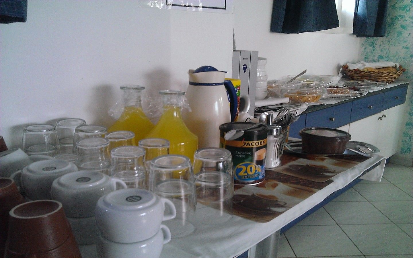 A kitchen counter with various items including glass bottles, a coffee maker, and a can of coffee.