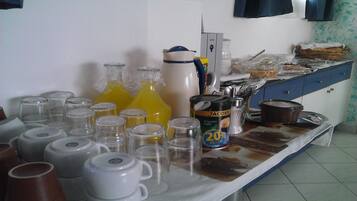 A kitchen counter with various items including glass bottles, a coffee maker, and a can of coffee.