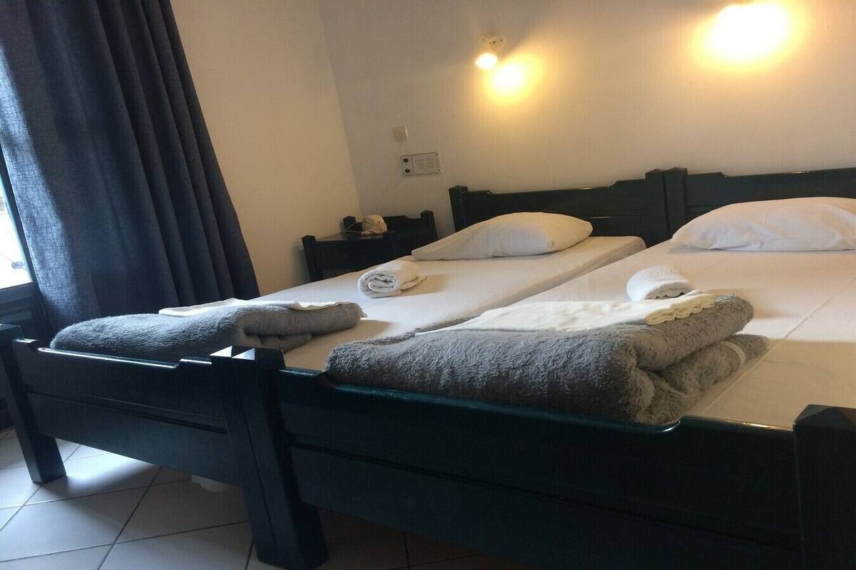 Un lit double avec deux oreillers, une table de chevet et une lampe.