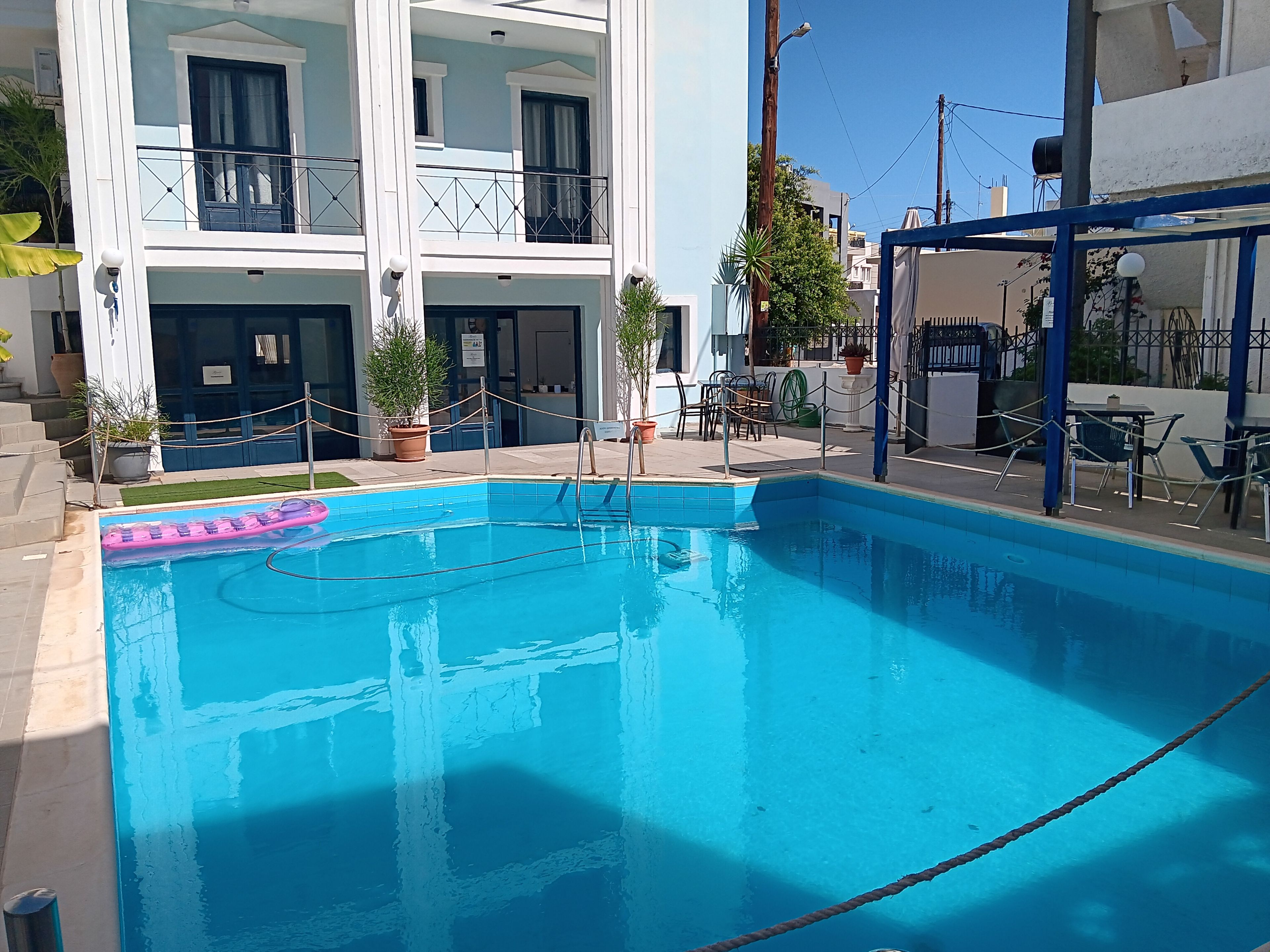 Ein Schwimmbecken mit Seilsperre, Blumentöpfen und Gartenmöbeln.