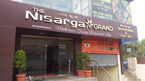 A building with a sign for 'The Nisarga Grand' and 'Bee Gee Complete'. - The Nisarga Grand Bangalore India (Bengaluru)