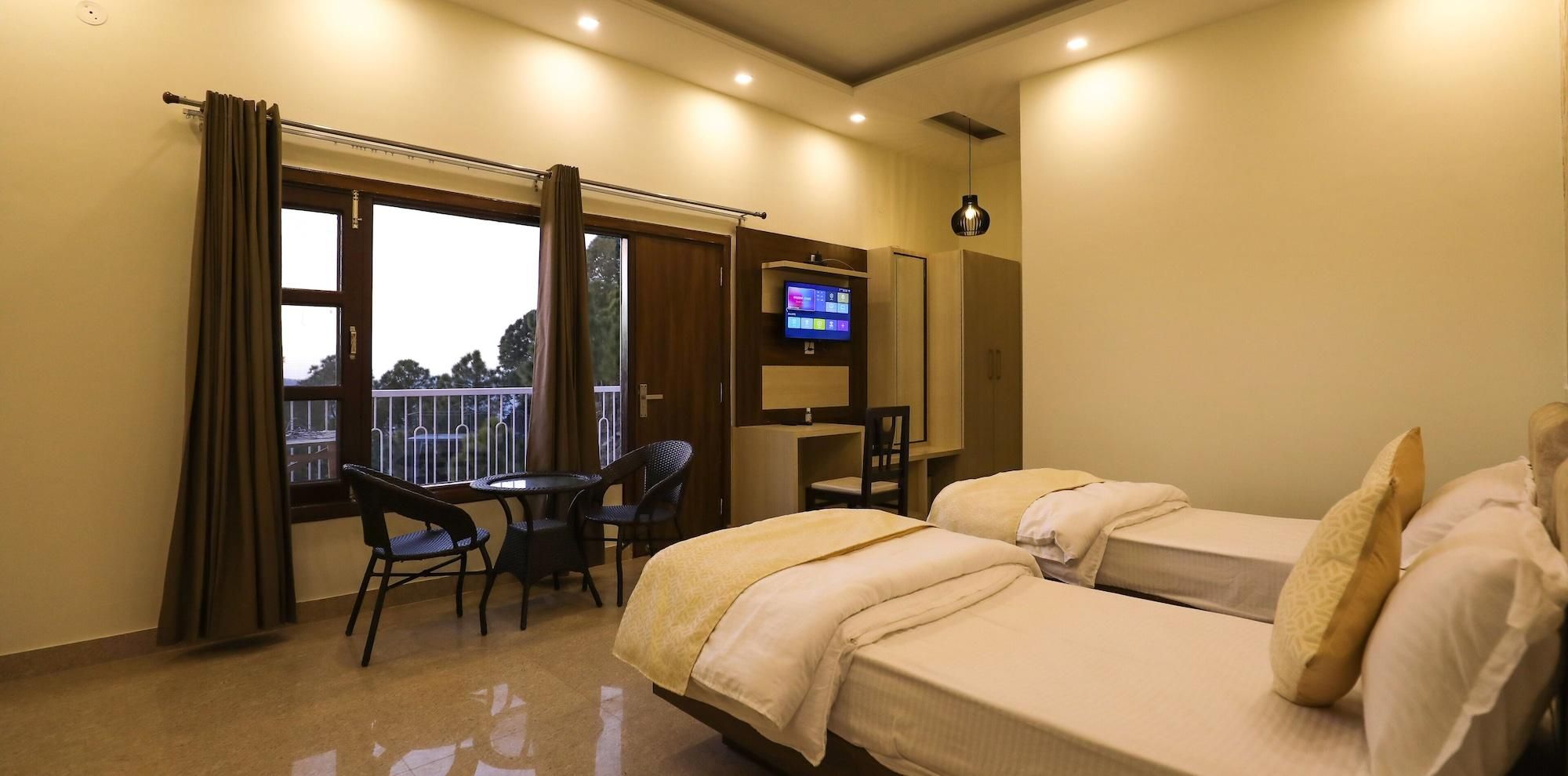 A hotel room with two beds, a TV, a desk, and a balcony with a view.