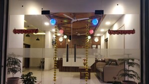 A reception area with a 'WELCOME' mat, potted plants, a reception desk, and a clock on the wall. - Hotel Le Halcyon Kasau (Solan)