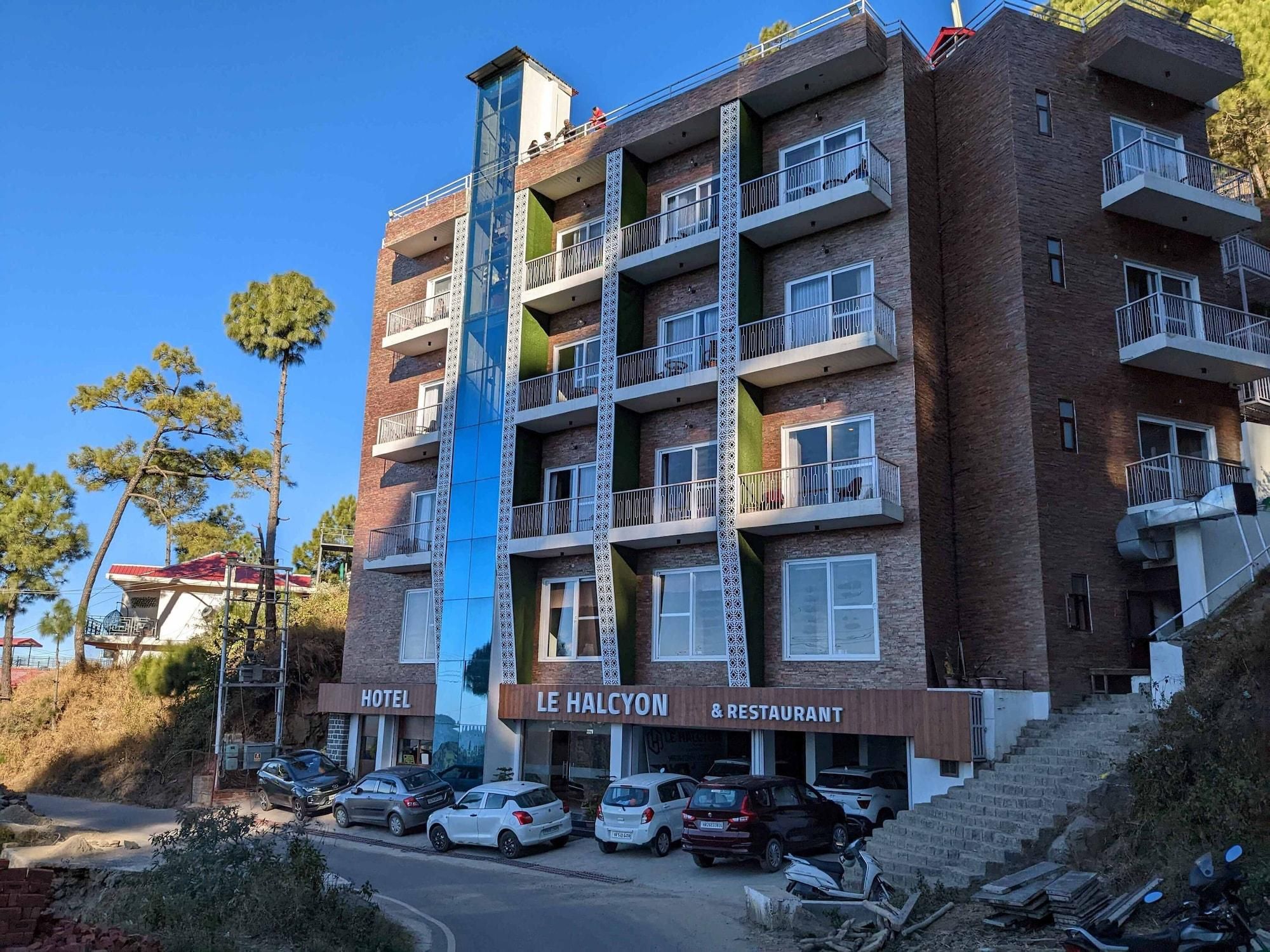 A multi-story building with balconies, a restaurant, and a hotel sign.