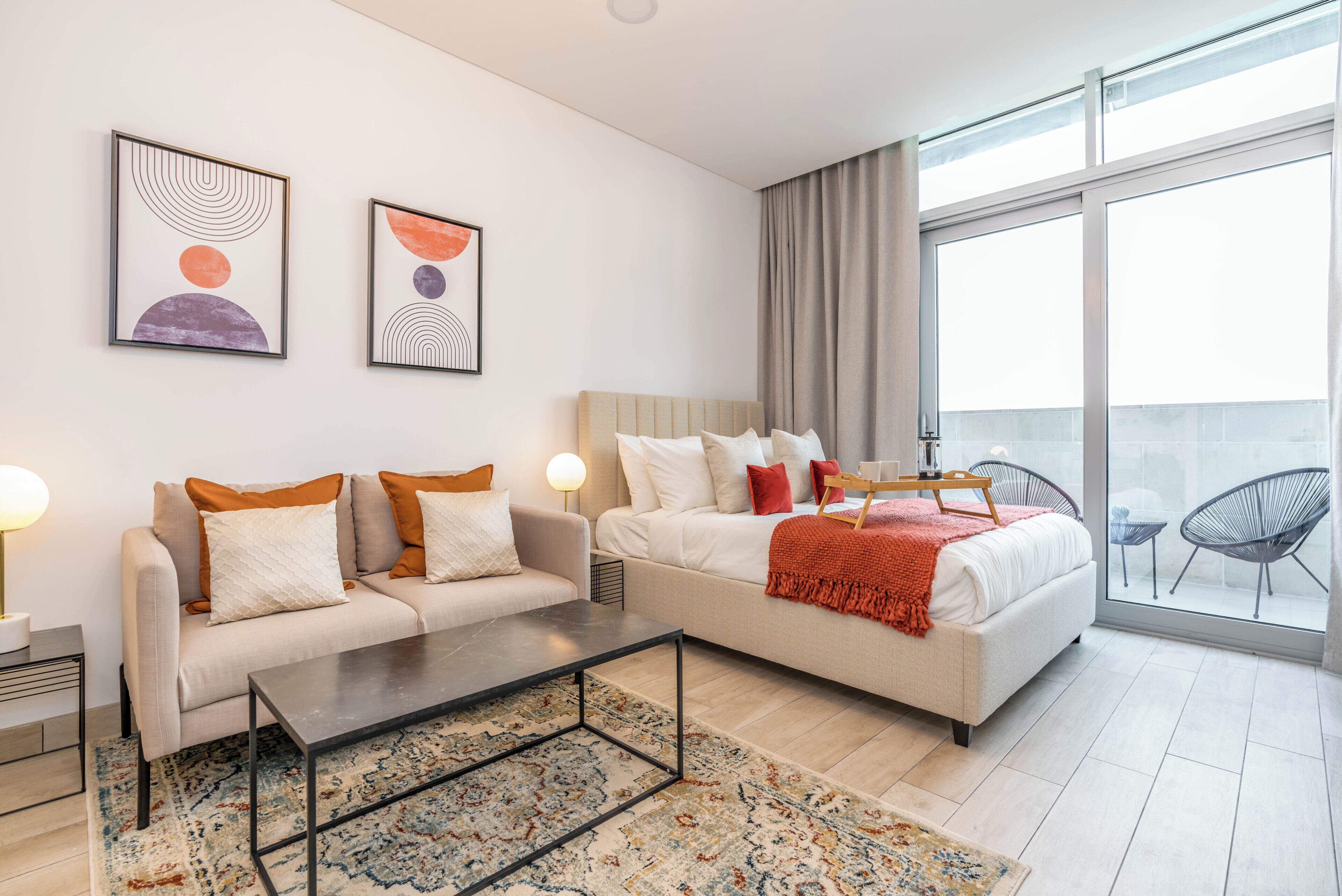 Ein modernes Hotelzimmer mit einer Couch, einem Bett, einem Couchtisch und einem großen Fenster mit Blick.