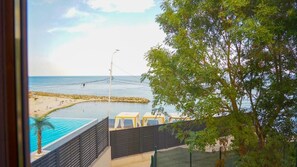 En vy över en strand med en pool, ett staket och ett träd.