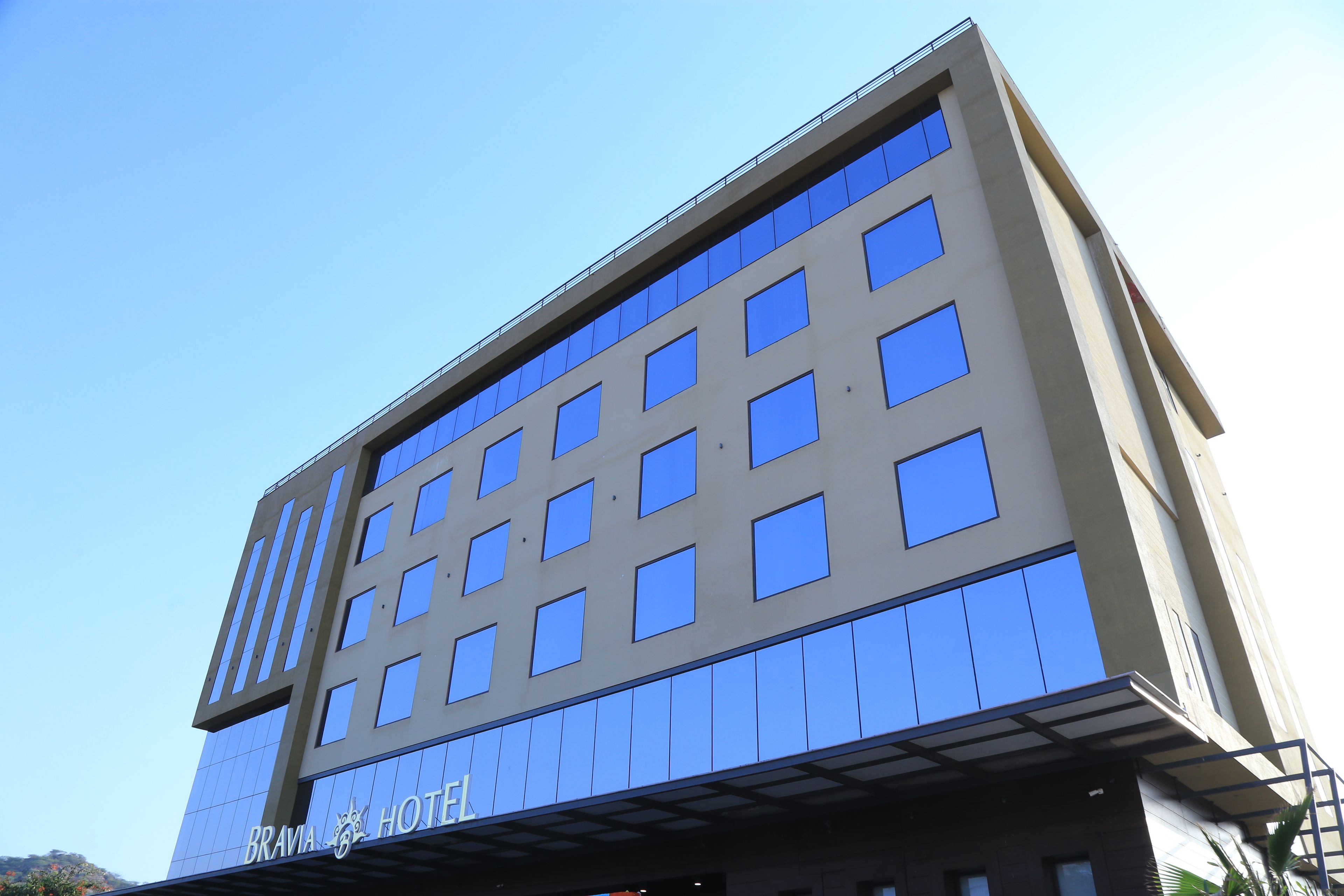 A multi-story hotel with a modern design, featuring a prominent 'BRAVIA HOTEL' sign at the entrance.