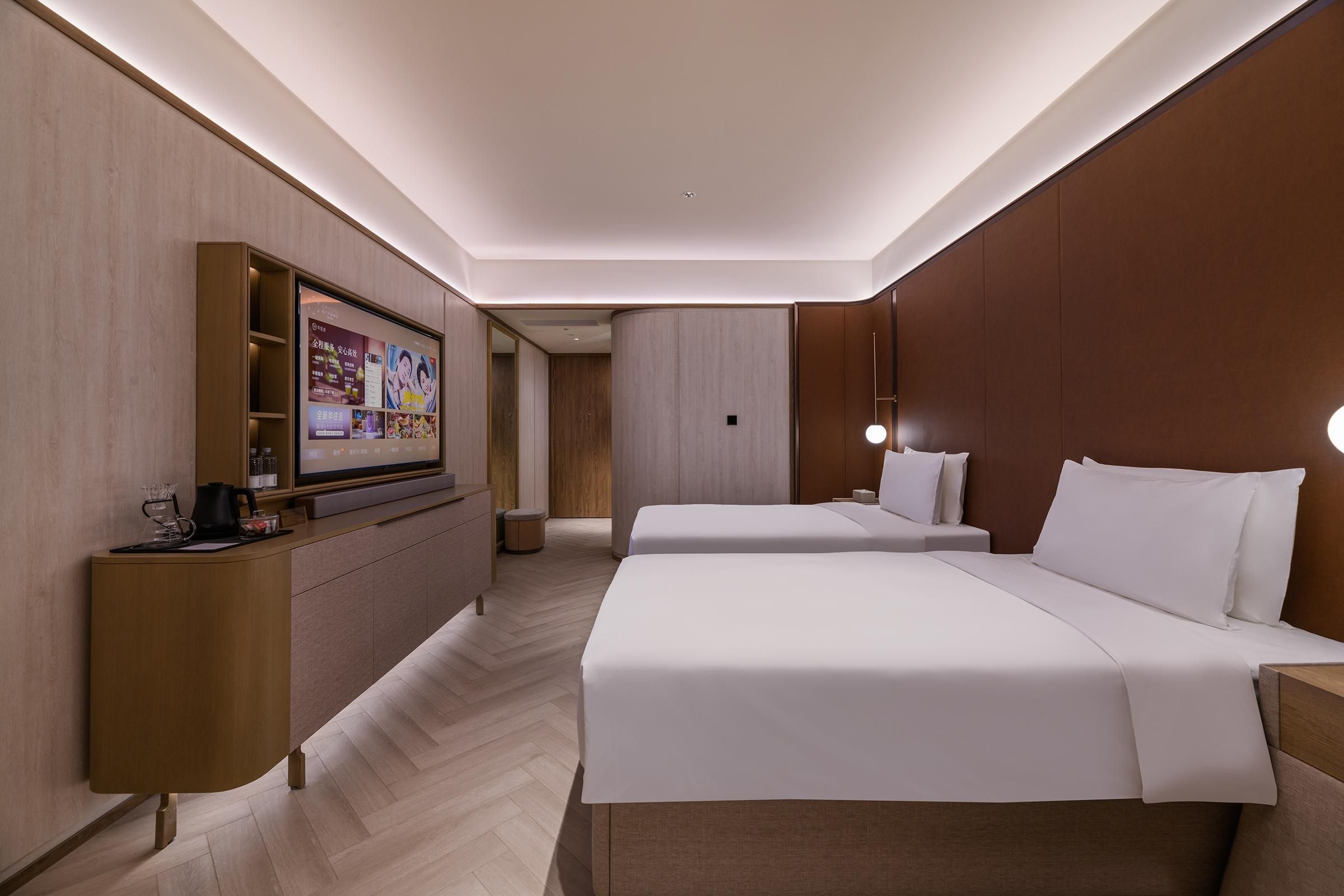 Una habitación de hotel con cama, mesitas de noche, televisor y escritorio con silla.