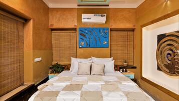 Un dormitorio con cama, mesitas de noche, aire acondicionado de pared y un adorno en la pared.